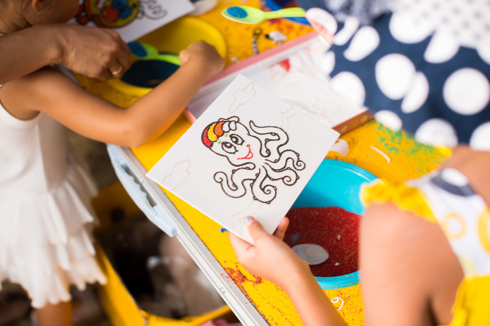 A child draws with colored sand picture. Cartoon characters.